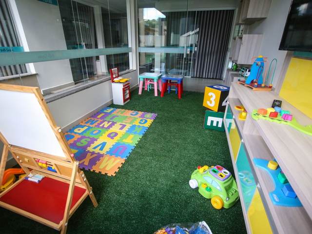 A bright playroom with a play mat, an easel, and toys
