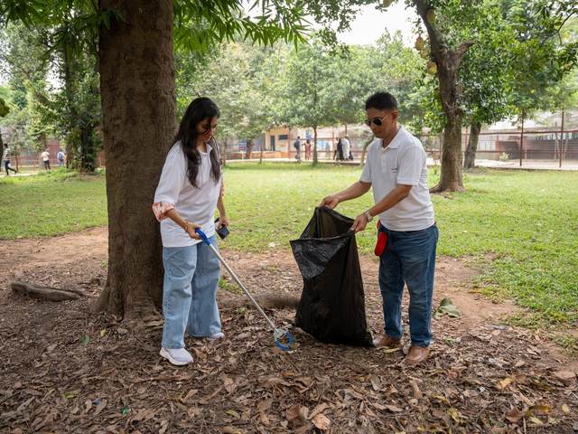 Two volunteers picking up litter in a park