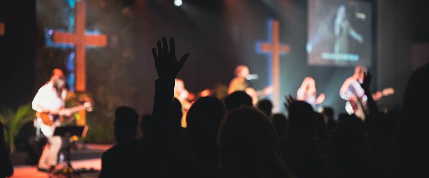 A worship band with guitars and singers leading a church service