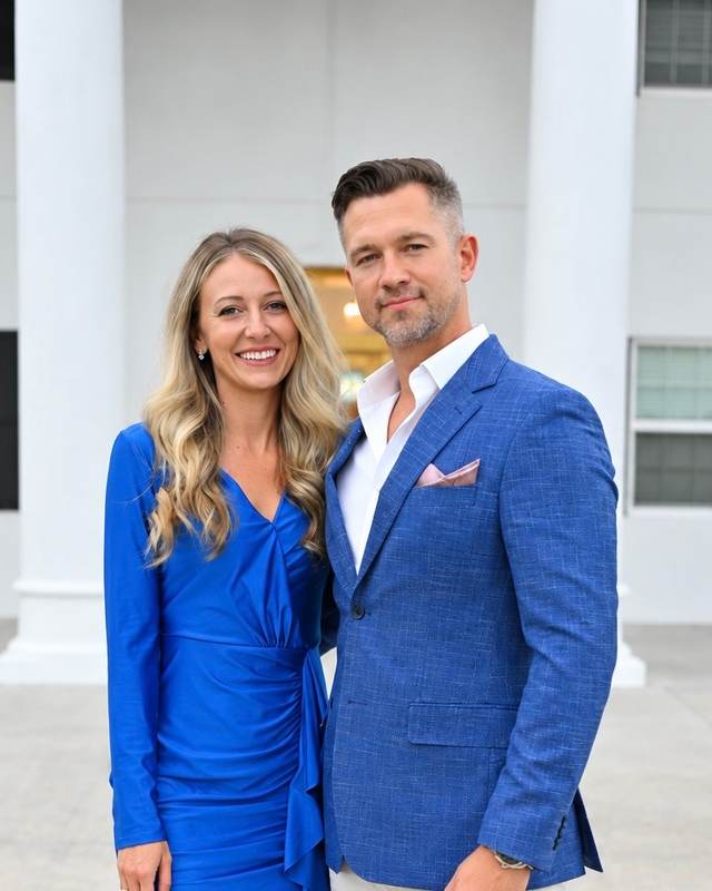 Pastor Filipp Timoshenko and his wife standing outside a white building with columns